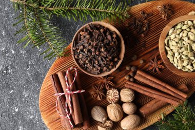 Farklı baharatlar ve köknar dalları koyu gri desenli masa, düz yatıyordu.