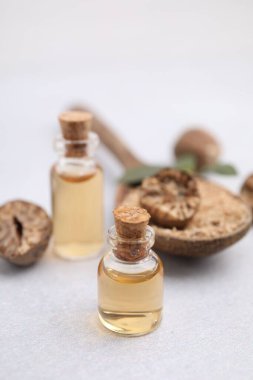 Nutmeg temel yağı, bütün ve yer fıstığı ışık masasında, yakın plan.