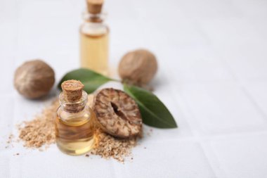 Nutmeg esaslı yağ ve fındıklar beyaz masada. Metin için boşluk