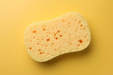 Sarı arkaplanda yeni sünger, üst görünüm