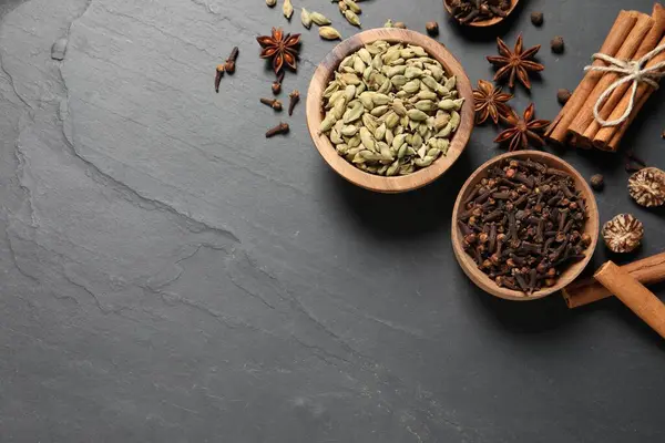 Koyu gri desenli masada farklı baharatlar var. Metin için boşluk