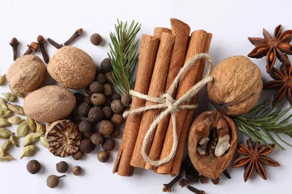 Beyaz masada farklı baharatlar ve köknar dalları var.