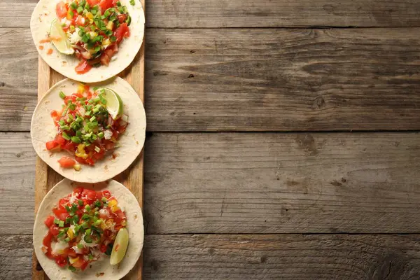 Sebzeli takolar, yeşil soğan, limon ve ketçap, ahşap masa, üst manzara. Metin için boşluk