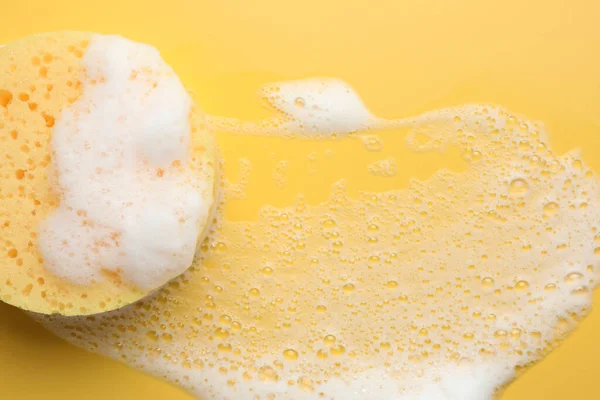 Sarı arka planda köpüklü sünger, üst manzara. Metin için boşluk