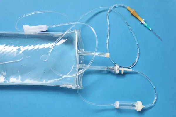 IV infusion set on light blue background, top view