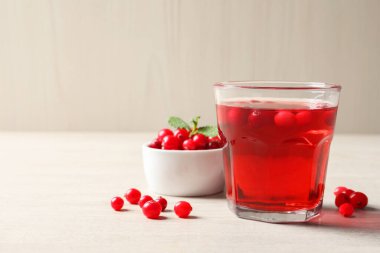 Hafif ahşap masada taze böğürtlen ve kızılcık suyu. Metin için boşluk