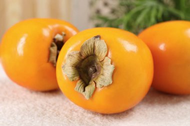 İçerideki açık renkli masada nefis olgun hurma ağaçları, yakın plan.