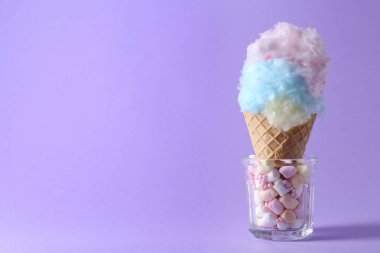 Mor arka planda gözleme külahında pamuk şeker, yakın plan. Metin için boşluk