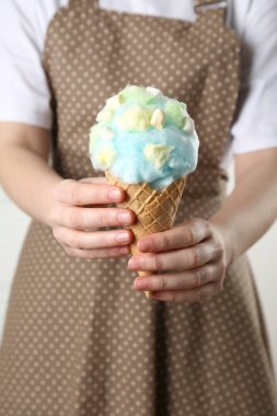 Elinde pamuk şekerli waffle külahı tutan kadın, yakın plan.