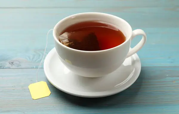 Açık Mavi Ahşap Masada Sıcak Içecekle Çay Poşeti Yakın Plan — Stok fotoğraf