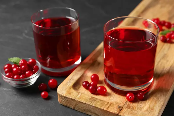 Lezzetli, ferahlatıcı kızılcık suyu ve gri dokulu masada taze böğürtlen.