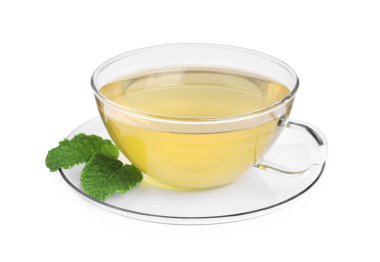 Cam fincanda taze yeşil çay, beyaz üzerinde izole edilmiş nane ve çay tabağı.
