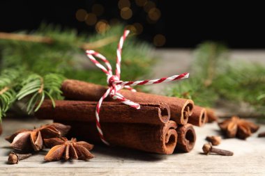 Ahşap masada farklı baharatlar ve köknar dalları, yakın plan.