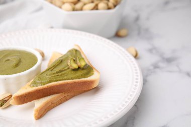 Fıstıklı krema, fındıklı ve tostlu beyaz mermer masa, yakın plan. Metin için boşluk