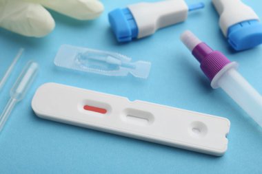 Açık mavi arkaplan üzerinde Covid-19 ekspres test kiti, yakın plan