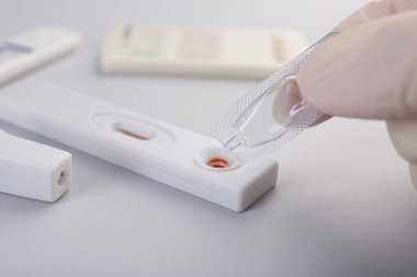 Doktor kullan-at ekspres test kasetine tampon çözeltisi bırakıyor.