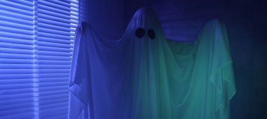 Ürkütücü hayalet. Pencerenin yanında, mavi ışıkla kaplanmış kadın.