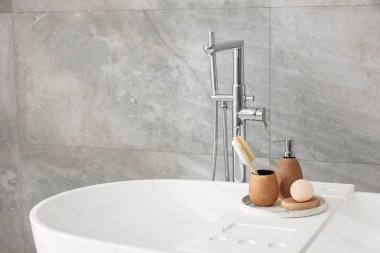 Banyodaki küvette farklı kişisel bakım ürünleri ve aksesuarlar.