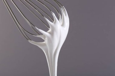 Gri arka planda krem şantili çırpma çırpma, yakın plan.