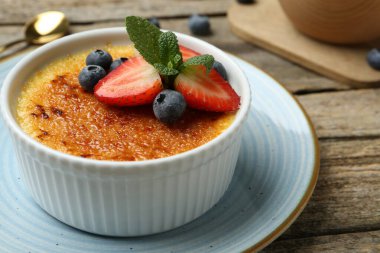 Böğürtlenli ve nane şekerli nefis creme brulee ahşap masada, yakın plan