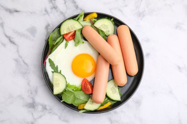 Haşlanmış sosis ve beyaz mermer masada kızarmış yumurta ile nefis bir kahvaltı.