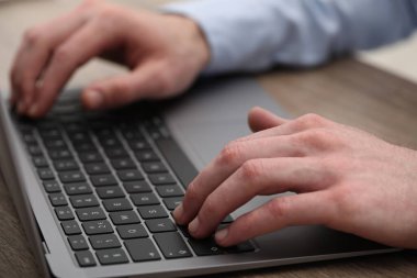 E-öğrenme. Çevrimiçi ders sırasında masadaki bilgisayarı kullanan adam, yakın plan.