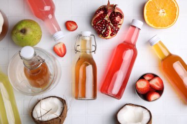 Cam şişelerdeki lezzetli kombu çayı ve beyaz fayanslı masada taze meyveler.