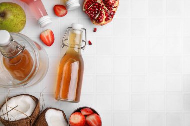 Cam şişelerde lezzetli kombu çayı ve beyaz fayanslı masada taze meyveler, düz yatak. Metin için boşluk