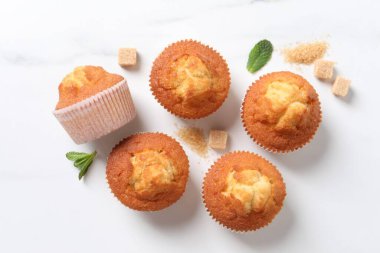 Lezzetli tatlı kekler ve kahverengi şeker beyaz mermer masa üzerinde, düz yatıyordu.