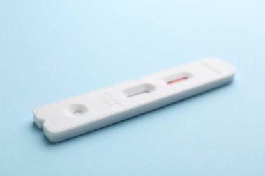 Açık mavi arkaplanda tek kullanımlık ekspres test, yakın plan