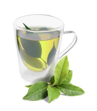 Cam bardakta yeşil çay ve beyaz yapraklar.