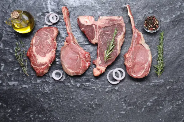 Taze çiğ sığır eti ve gri desenli masada farklı baharatlar. Metin için boşluk