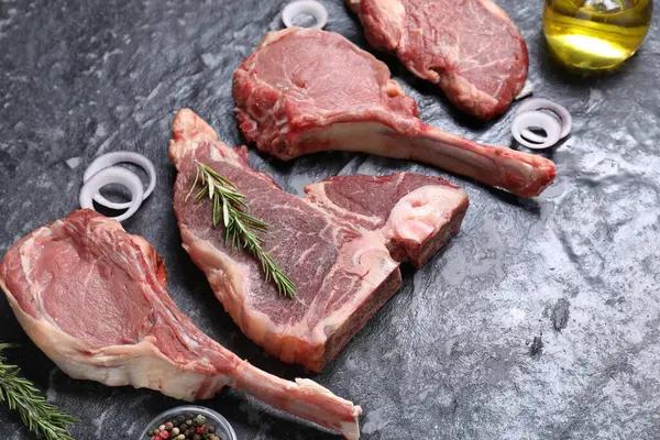 Taze çiğ et ve gri dokulu masada farklı baharatlar.