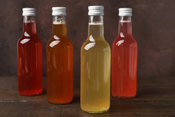 stock image Delicious kombucha in glass bottles on wooden table