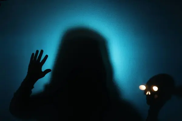 Silhouette Fantôme Crâne Derrière Verre Sur Fond Bleu — Photo