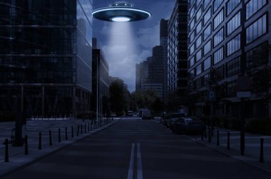 Uzaylı uzay gemisi şehirdeki binaların üzerine ışık saçıyor. UFO, dünya dışı ziyaretçiler.
