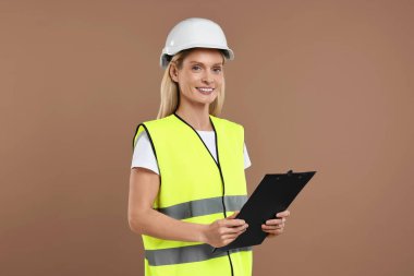 Kask takan mühendis kahverengi arka planda pano tutuyor.