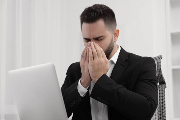 Sick man coughing at workplace in office