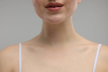 Güzellik konsepti. Gri arka plandaki kadın, yakın plan.