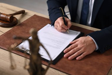 Ofisteki ahşap masada çalışan noter, yakın plan.