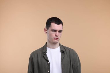 Bej arka planda üzgün bir adamın portresi