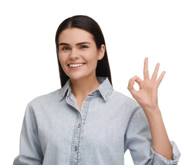 Temiz dişleri olan, gülümseyen ve beyaz arka planda iyi niyet gösteren genç bir kadın.