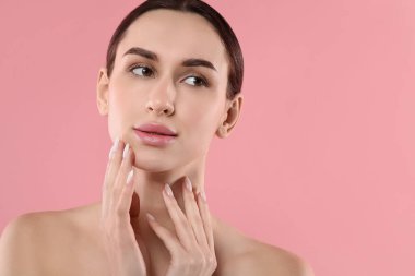 Pembe arka planda güzel bir genç kadının portresi. Metin için boşluk