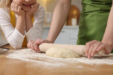 Ekmek yapıyorum. Anne ve kızı mutfaktaki ahşap masada hamuru yuvarlıyor.