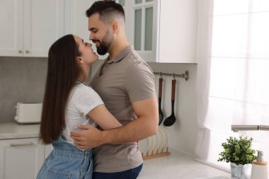 Sevecen bir çift mutfakta sarılıyor. Metin için boşluk