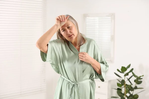 Menopause. Woman suffering from hot flash in bathroom