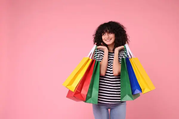 Pembe Arka Planda Alışveriş Torbaları Olan Mutlu Genç Bir Kadın — Stok fotoğraf