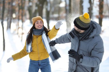Mutlu çift kış günü dışarıda kartopu oynuyor.