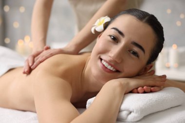Spa salonundaki kanepede sırt masajı yaptıran kadın.