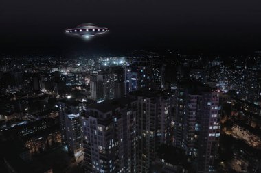 Uzaylı uzay gemisi gece şehrin üzerinde uçuyor. UFO, dünya dışı ziyaretçiler.